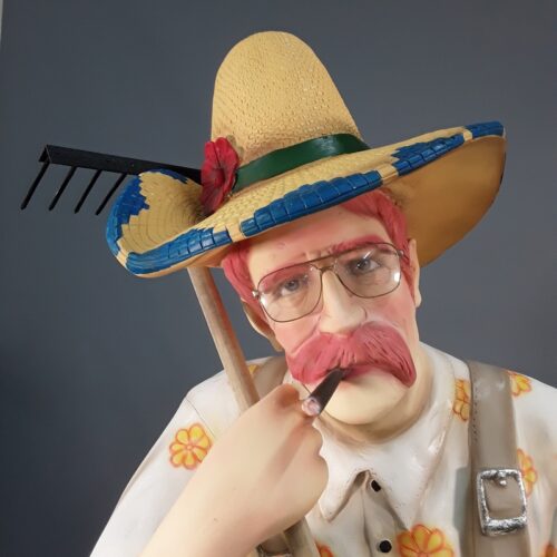 Tête d'un jardinier en résine avec des lunettes ,des moustaches et un cigare dans la bouche